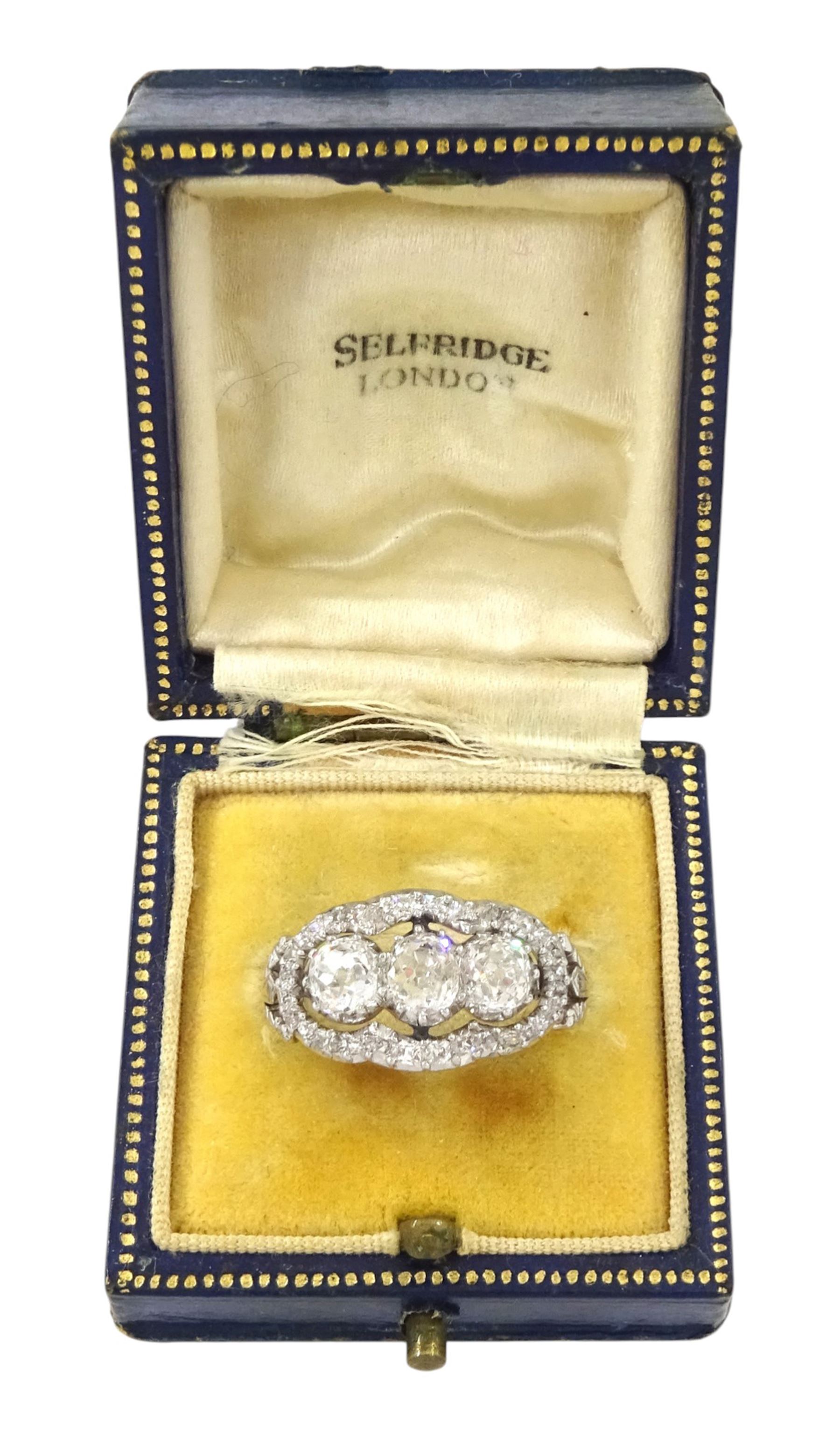 Late 19th / early 20th century platinum diamond ring, three old cut diamonds, in an openwork setting surrounded by further old cut diamonds, with pierced design shoulders, principal three diamonds total weight approx 1.45 carat, in a velvet and silk lined box by Selfridges