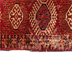 Vintage Bokhara hand-knotted rug, madder field woven in rows of octagonal Tekke guls arranged in vertical columns, each enclosing angular cruciform devices and tribal motifs, divided by narrow indigo lines, within multiple geometric borders incorporating stepped lozenges and latch hook devices, with cotton fringe ends 