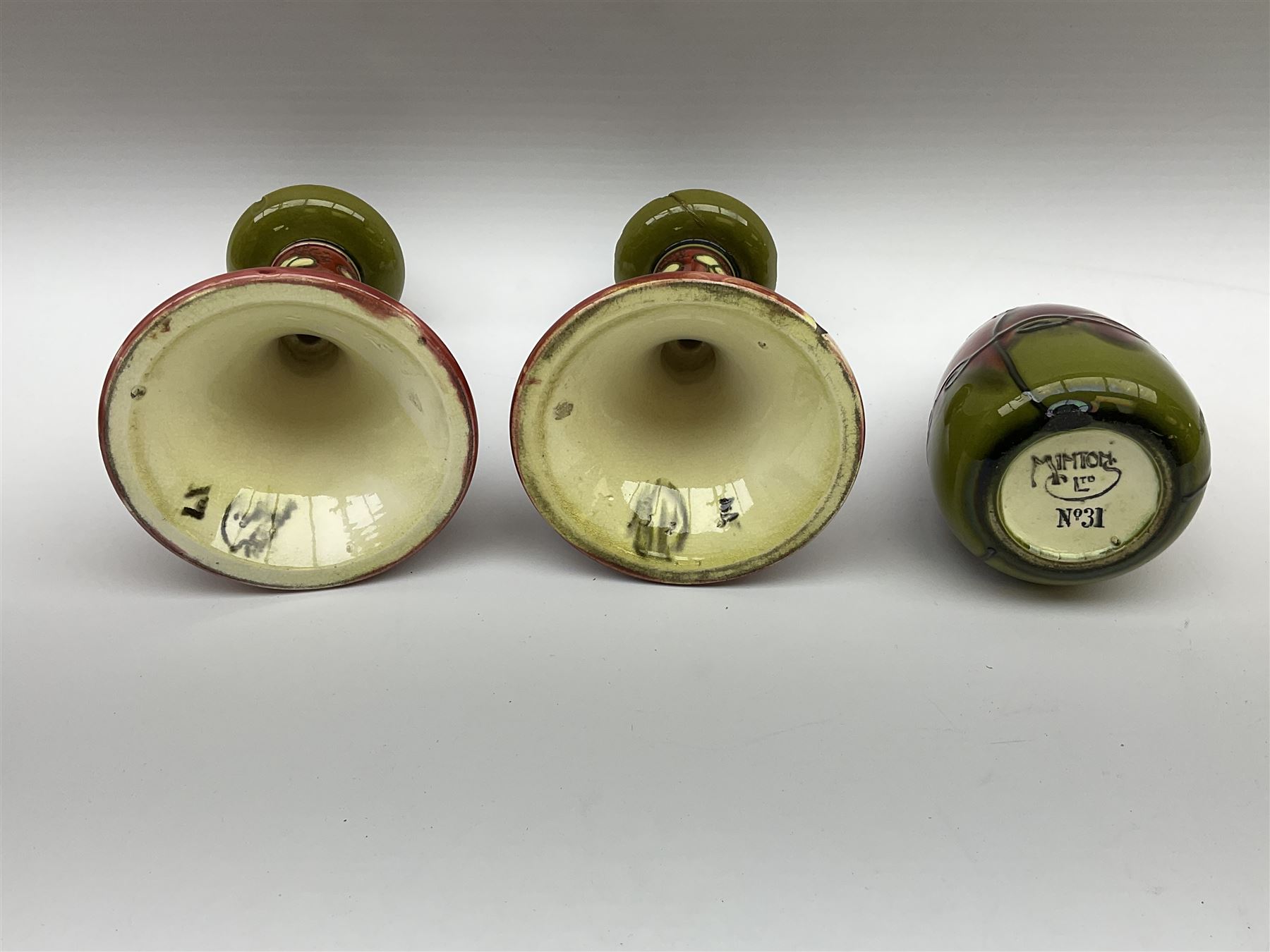 Minton Secessionist vase, with tube-lined stylised flower head decoration upon a red and green ground, printed mark to base 'Minton Ltd, No. 31', together with a matching pair of Minton Secessionist candle sticks, candlestick H17cm