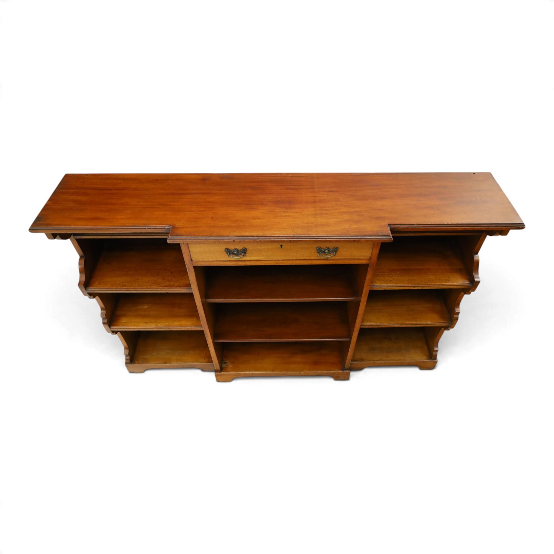 Early 20th century mahogany breakfront open bookcase, the shaped rectangular top with moulded edge, fitted with single frieze drawer over to open shelves, flanked by two shelves to each side with shaped uprights, on bracket feet