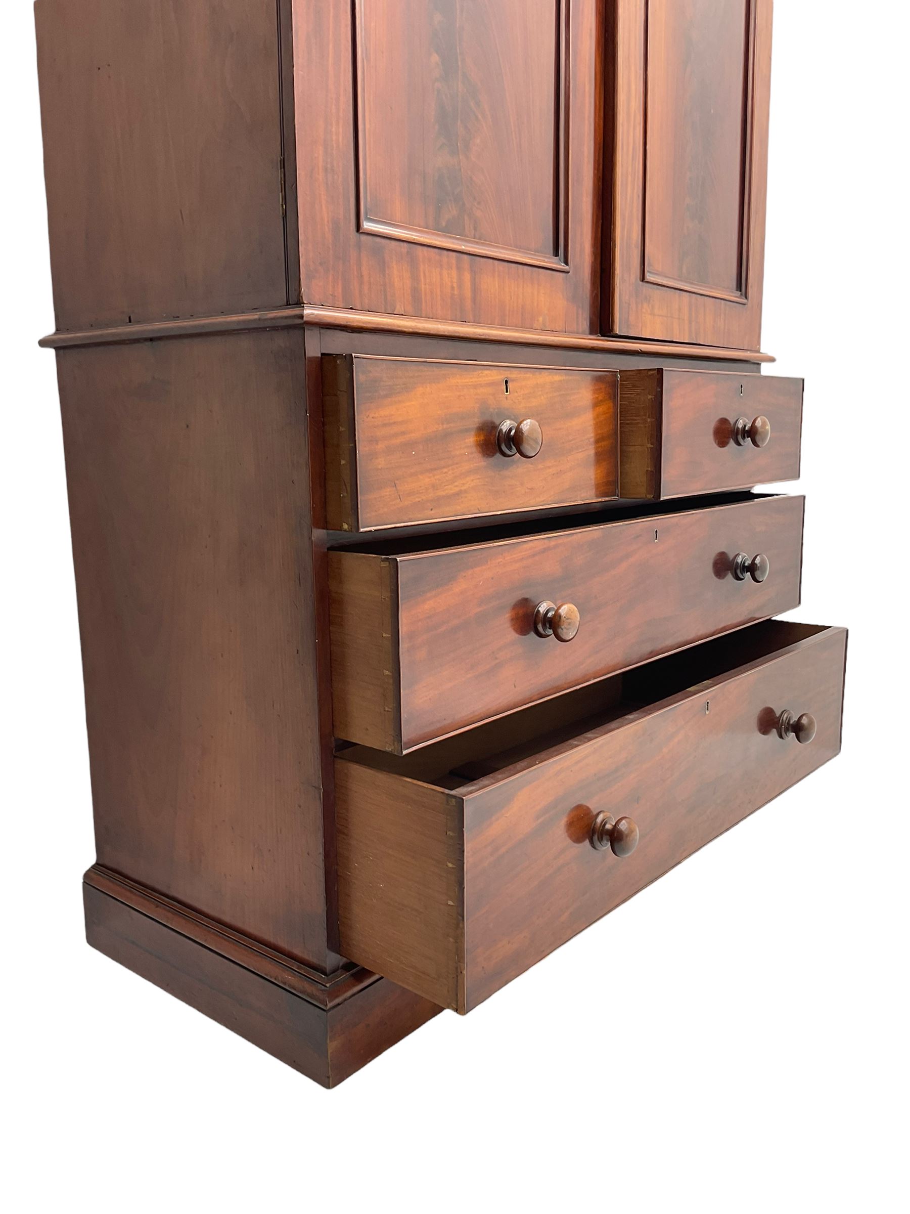 Victorian mahogany linen press, projecting moulded cornice, two doors with arched panels enclosed four linen slides, the lower section fitted with two short and two long drawers, on plinth base