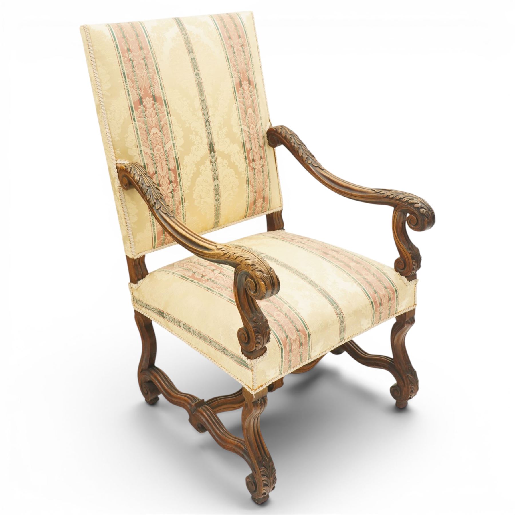 Pair of French Louis XIV design carved walnut open throne armchairs, high back and sprung seat upholstered in foliate damask fabric, acanthus carved scroll form arms over reeded and scrolled supports united by shaped stretcher
