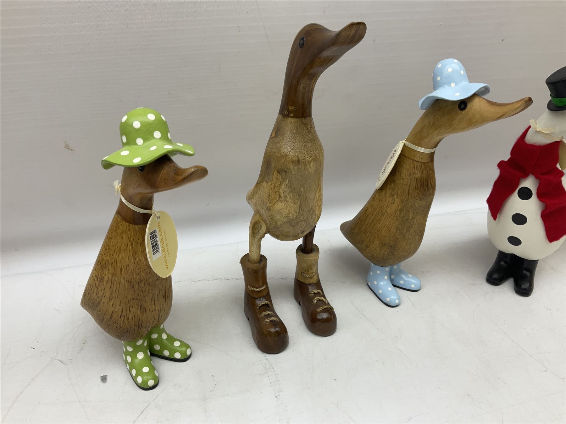 Quantity of the Duck Company UK DCUK carved bamboo root ducks, modelled wearing rain hats and rain boots etc, together with other similar carved wood ducks, tallest H26cm