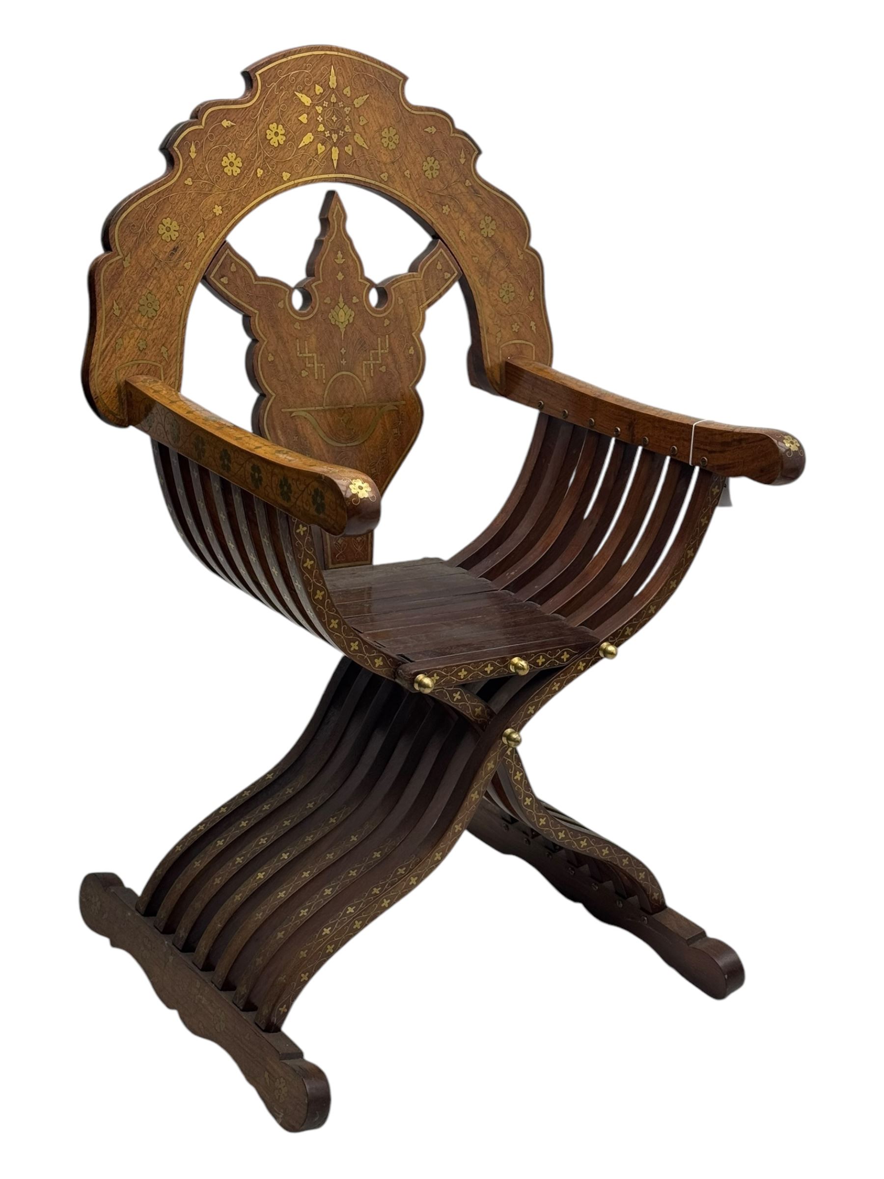 Late 20th century brass inlaid hardwood throne chair, curved X-frame form, raised shaped back inlaid with trailing leafy branches and flower heads, on sledge feet 