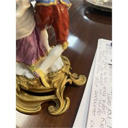 Mid 18th century Meissen figure group, The Tyrolean Dancers, circa 1740, modelled as two swirling figures with their arms linked, he in yellow hat with red rosette, blue jacket, red breeches with red rosette, and yellow shoes with green rosette, she in white blouse with red ribbons, yellow and red bodice, white apron over puce skirt and yellow shoes with green rosettes, her hair fashioned into two plaits secured by red ribbon, upon a shaped mound base, within a scrolling gilt metal mount, with blue crossed swords mark to base, overall H19cm
