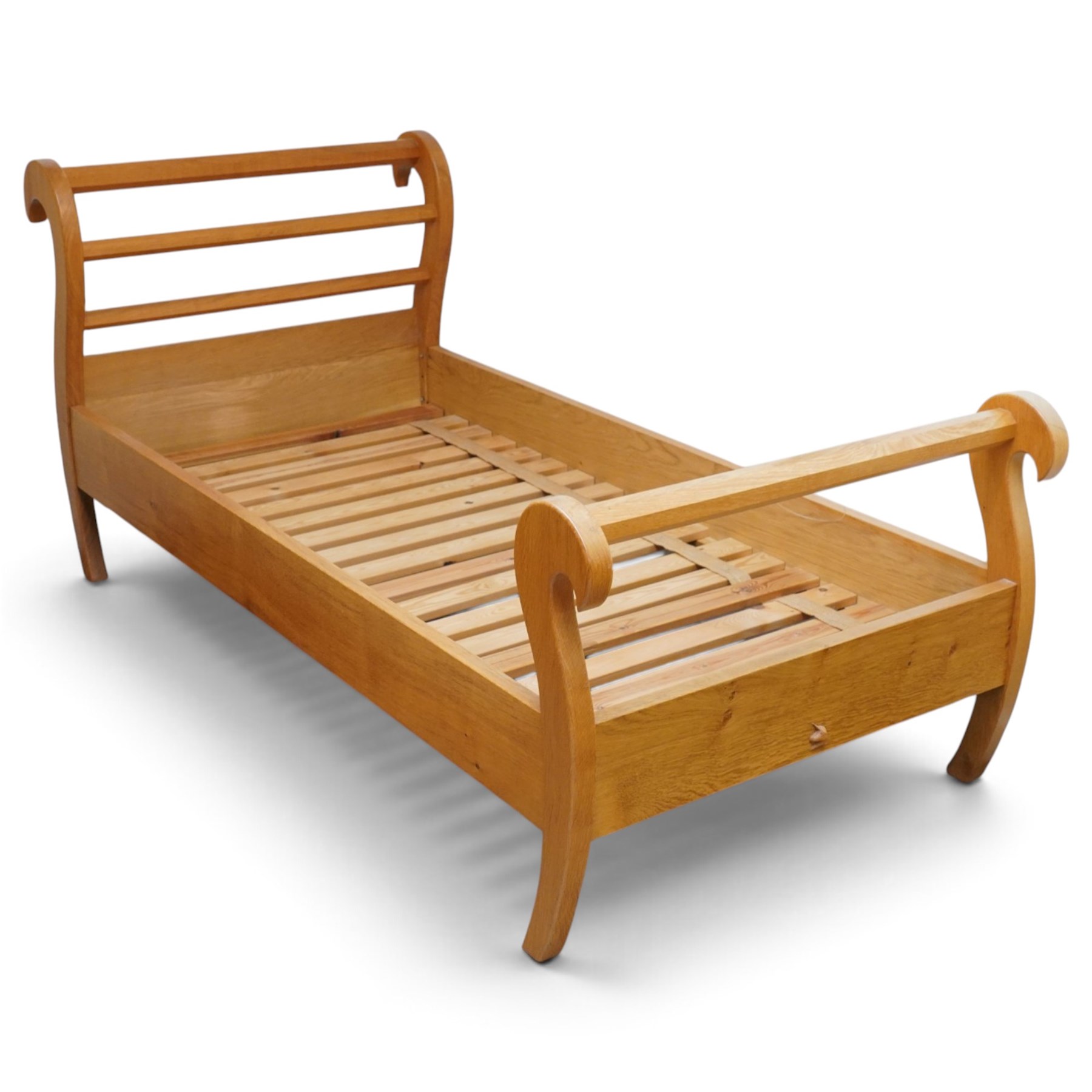 Unicornman - pair of craftsman-made oak single beds, of sleigh shape with scrolled head and foot-boards with octagonal stretchers, slatted base, raised on inward-splayed squared supports, applied with carved unicorn signature, by Geoff Gell of Coxwold