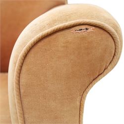 Victorian mahogany framed armchair of traditional shape, the high sprung rolled back over out-swept arms, deep sprung seat over turned feet with ceramic castors, upholstered in pale salmon pink fabric