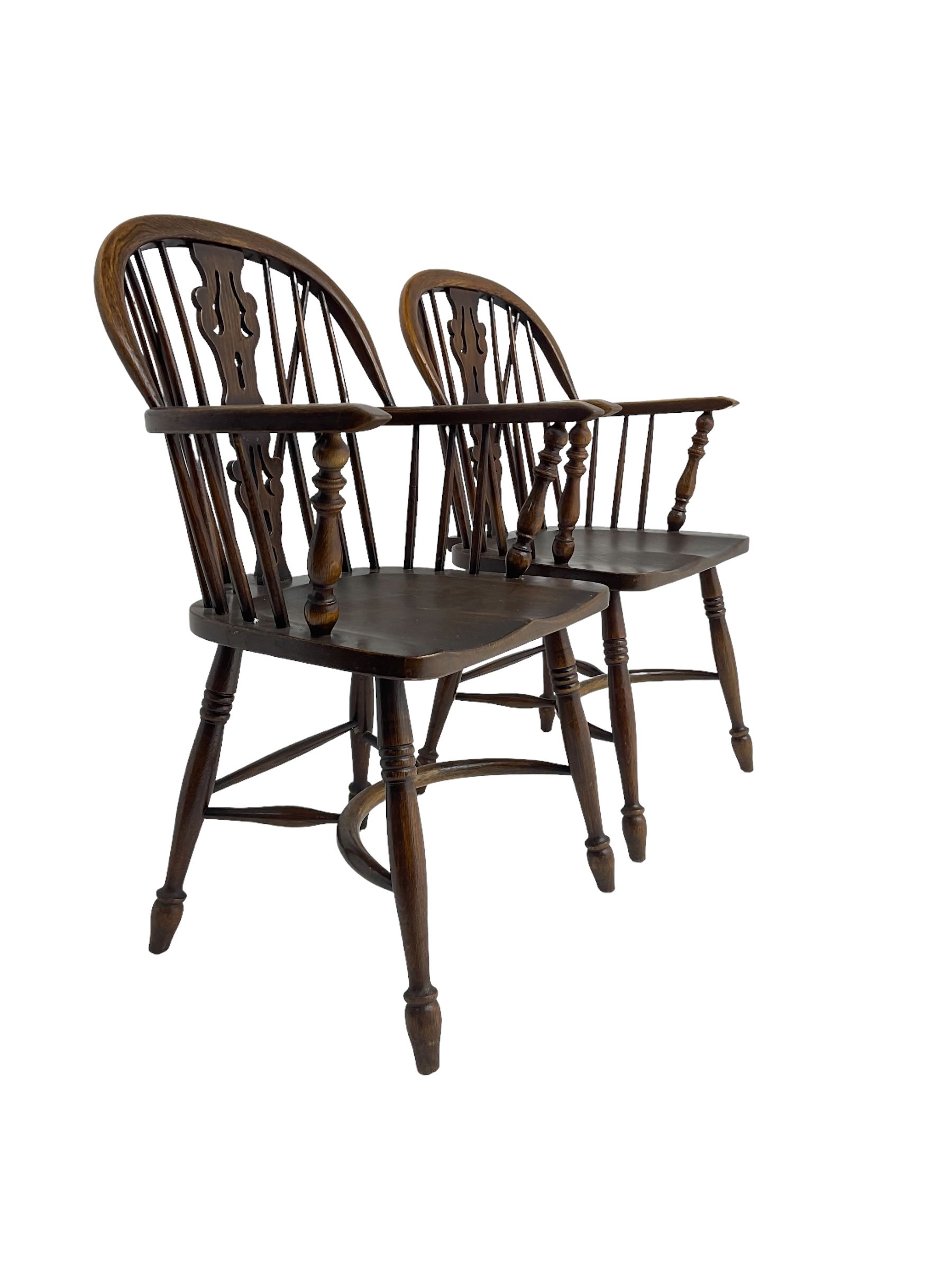 Pair late 20th century oak Windsor elbow chairs, double hoop and stick back with pierced and fretwork work splat, dished seat on turned supports joined by crinoline stretcher