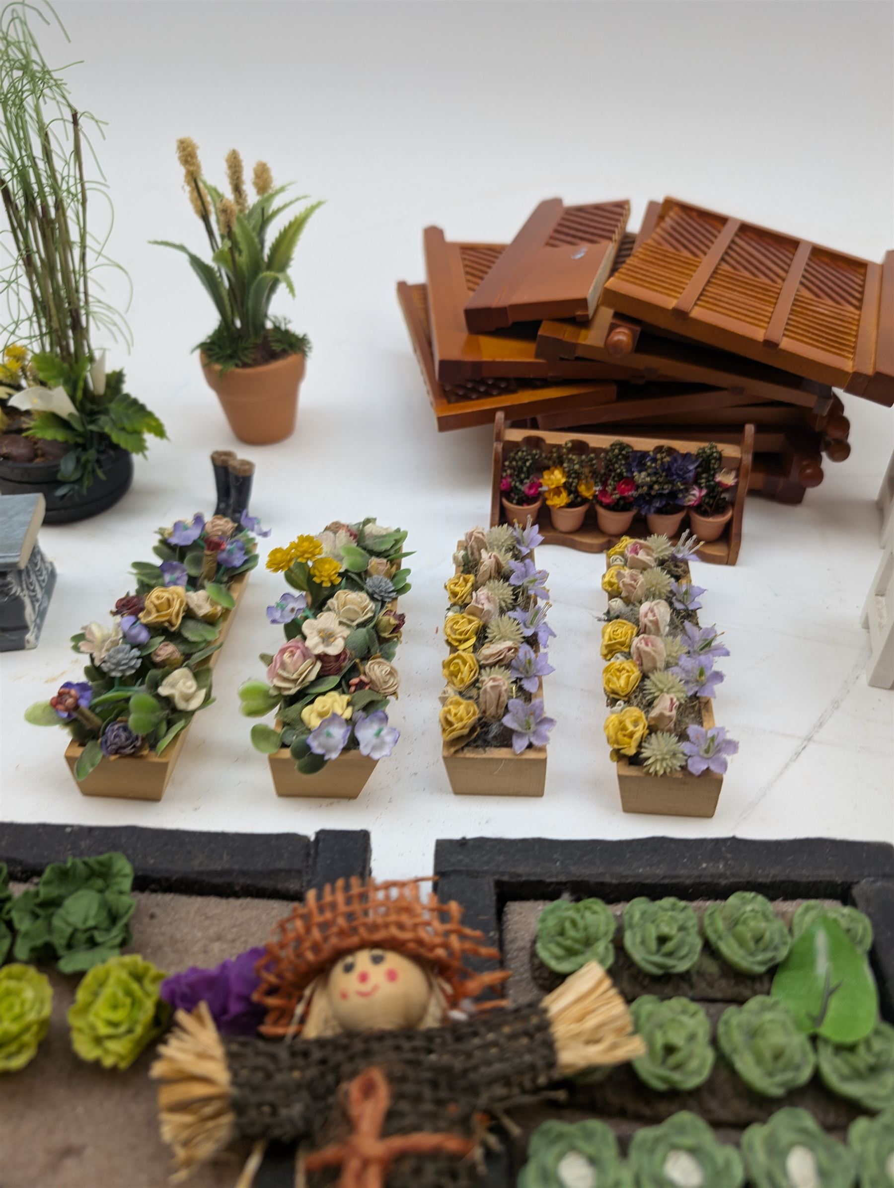 1:12 scale dolls house allotment and garden accessories, including wooden shed on a stone effect base, two vegetable patches, terracotta plant pots with flowers and foliage, stone effect plant pots, other planters, loose sunflowers, scarecrow, rabbit hutch, garden tools, fencing panels, etc 