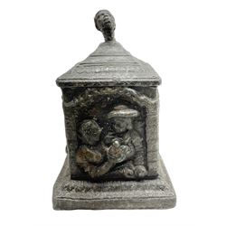 19th century lead tobacco box, the body of square form decorated with panels of courting couples in relief supporting stepped tapering lid with figural male head finial, H18.5cm