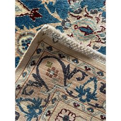 Persian Nain blue and ivory ground rug, wool with silk inlay, overall arabesque design, central medallion surrounded by interlacing and scrolled leafy branches and palmettes, the scrolling border decorated with stylised plant motifs, within guard stripes