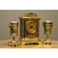  Late 19th/early 20th century brass clock garniture, architectural cased clock with twist columns, Arabic dial signed 'Pearce & Sons, Leeds', twin train movement striking the hours on coil, urn shaped garnitures mounted with cherubs and winged motifs  