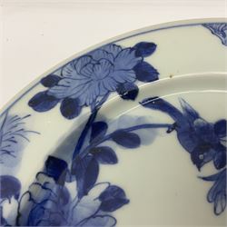 Japanese Meiji period Arita blue and white plate, of circular form, painted with riverside landscape and bird upon flowering branch, with character mark beneath, D24.5cm, together with two 18th century Chinese blue and white plates, each painted with floral design, each approximately D22.5cm