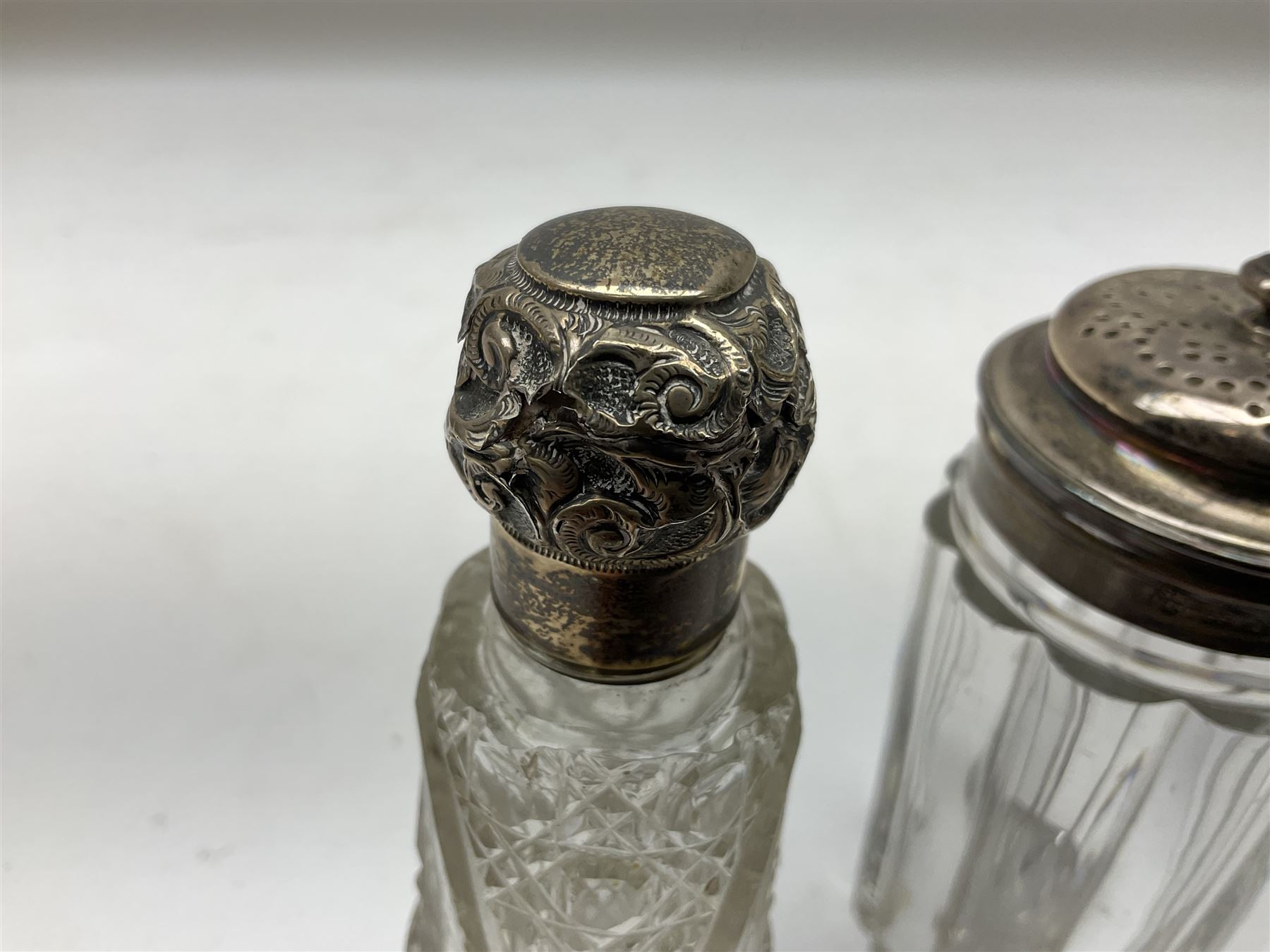 Edwardian silver mounted purse, with circular panel engraved with initials, and hammered finish, hallmarked William Comyns & Sons, London 1903, H14cm, together with three dressing table glass jars with hallmarked silver covers, and a hallmarked silver mounted buffer 