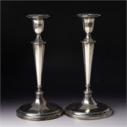 Pair of silver candlesticks with octagonal tapering stems and circular weighted bases H30c...