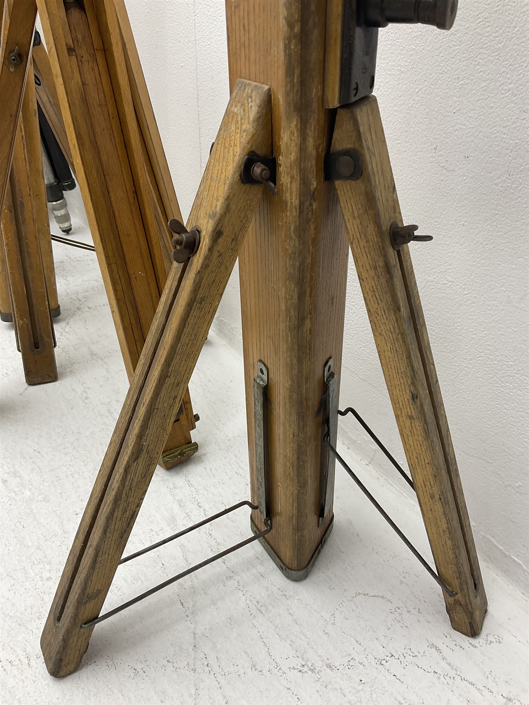 Three wooden adjustable tripods for plate cameras, together with a Linhof of Munchen metal tripod in a canvas case 