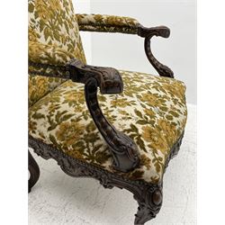 Late 19th century walnut open armchair, upholstered in floral patterned fabric, acanthus scroll carved arm terminals with scallop and cartouche carved supports, wide serpentine seat, shell and scrolled foliate carved apron, on scrolled cabriole supports