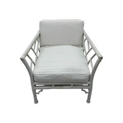 Late 20th century faux bamboo conservatory sofa, white painted frame with geometric openwork back and sides, loose cream cushions, on cylindrical supports (W134cm, D76cm, H80cm); matching armchair (W75cm, D76cm, H80cm); matching coffee table with glass insert (W46cm, D45cm, H36cm)