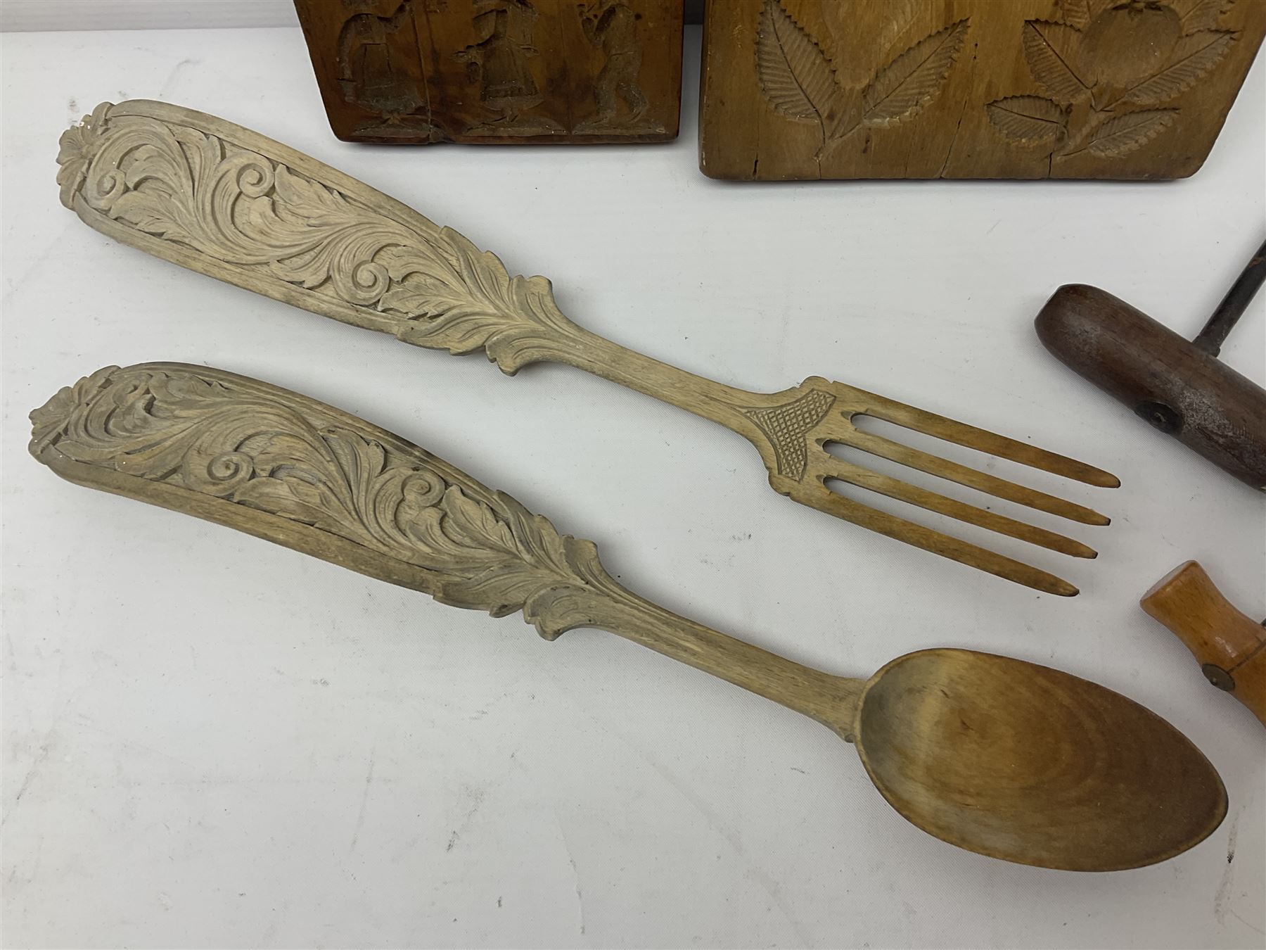 Two wooden biscuit moulds, carved loving spoon and fork, and two bradawls 