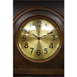  Early 20th century oak longcase clock, arched case with convex glass bezel, shaped stepped arched trunk door with bevelled glass, carved scroll mount, circular dial with black Arabic numerals, triple weight driven movement chiming the hours and half on rods, engine turned back plate stamped for 'Hans Winterhalder', H196cm  