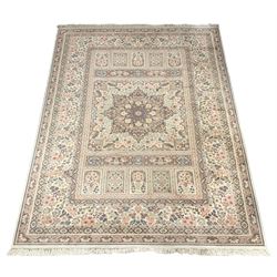 Large Persian design rug carpet, pale ground with large central rosette medallion, the field divided into multiple rectangular panels, overall floral decoration, repeating border