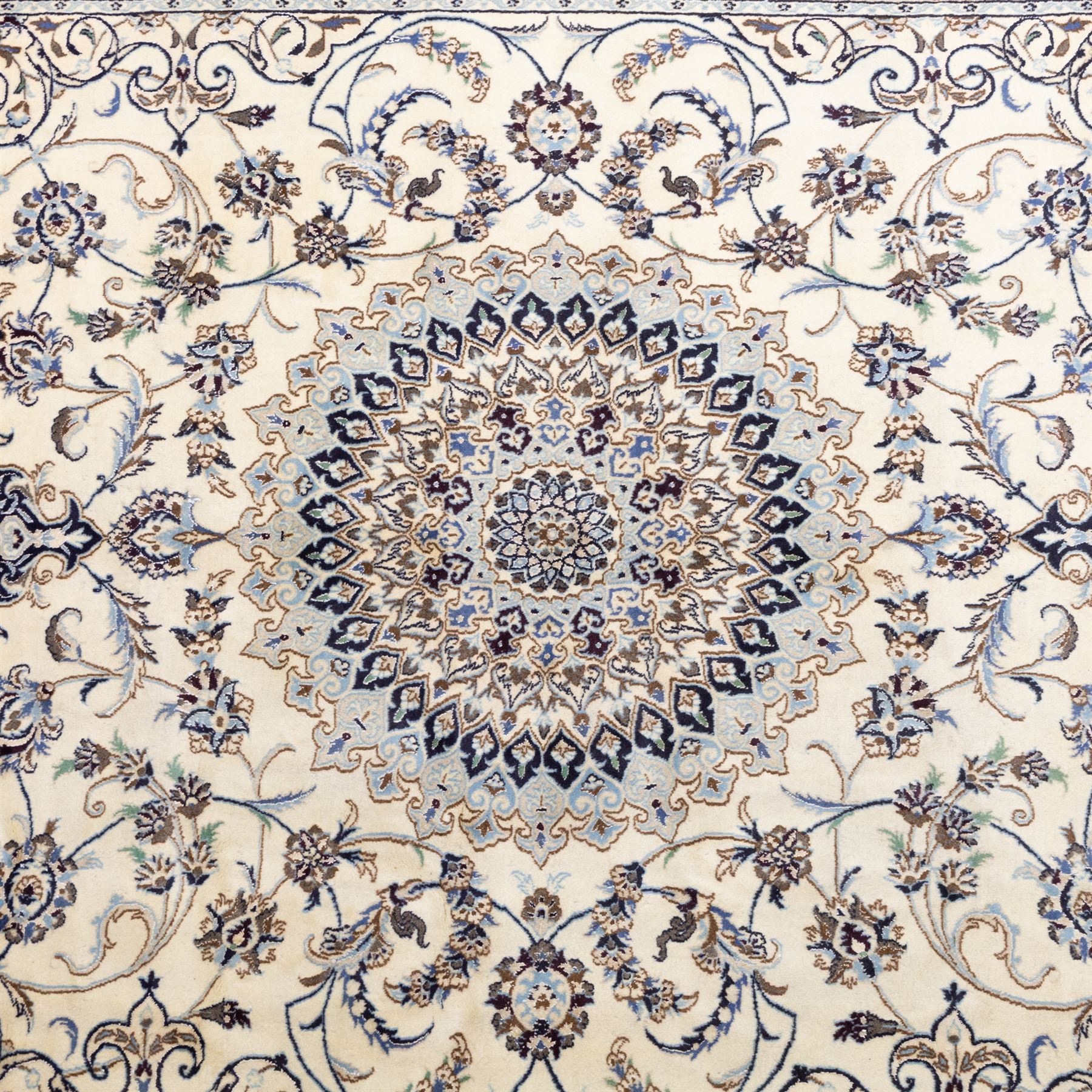Central Persian Nain hand-knotted carpet, wool with silk highlights, ivory field with central radiating medallion surround by an intricate arrangement of scrolling vines and floral motifs, within conforming spandrels and matching border, cotton fringe ends 