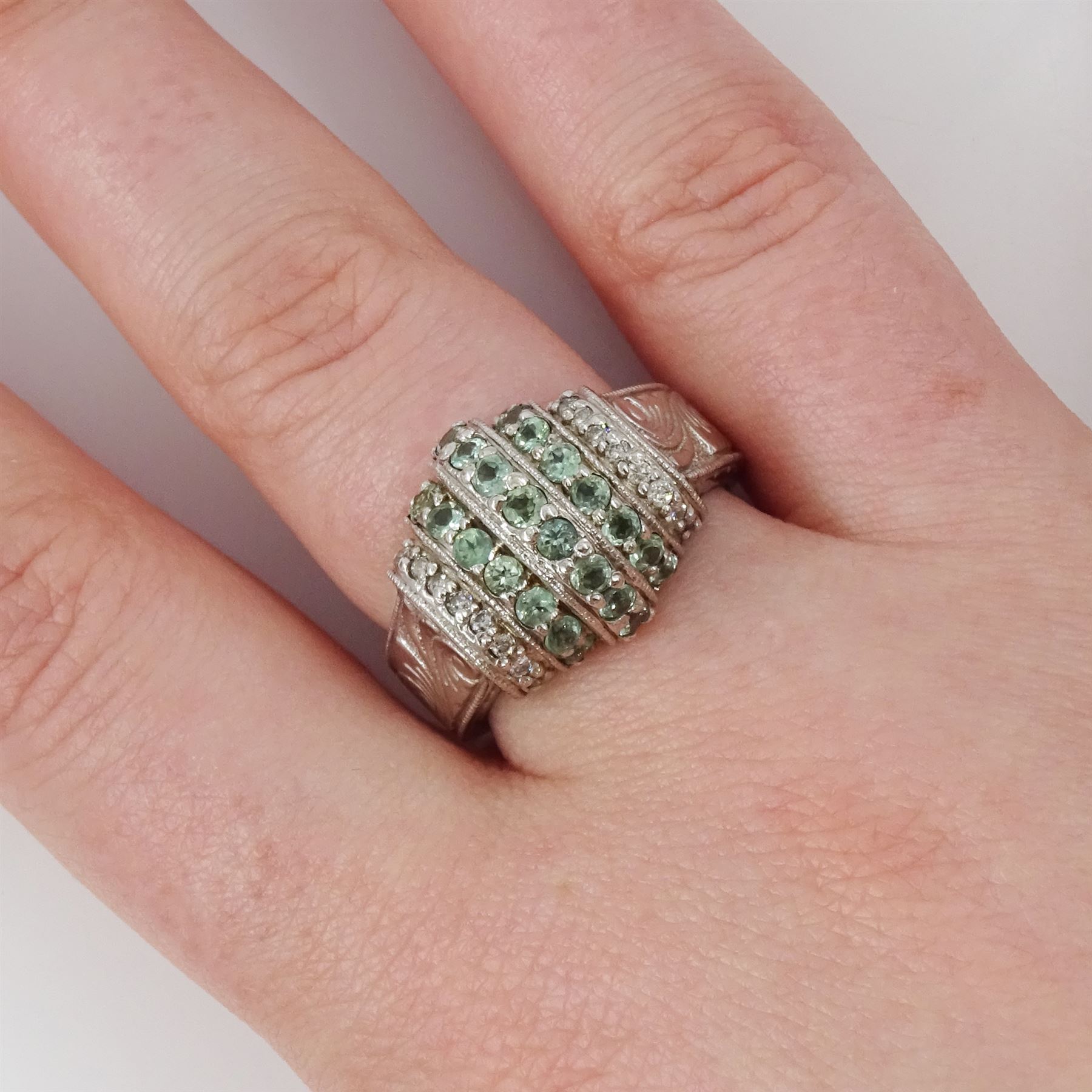 14ct white gold alexandrite and diamond stepped design ring, three rows of round cut alexandrite's, with a row of single cut diamonds either side, the shoulders with engraved foliate decoration, hallmarked