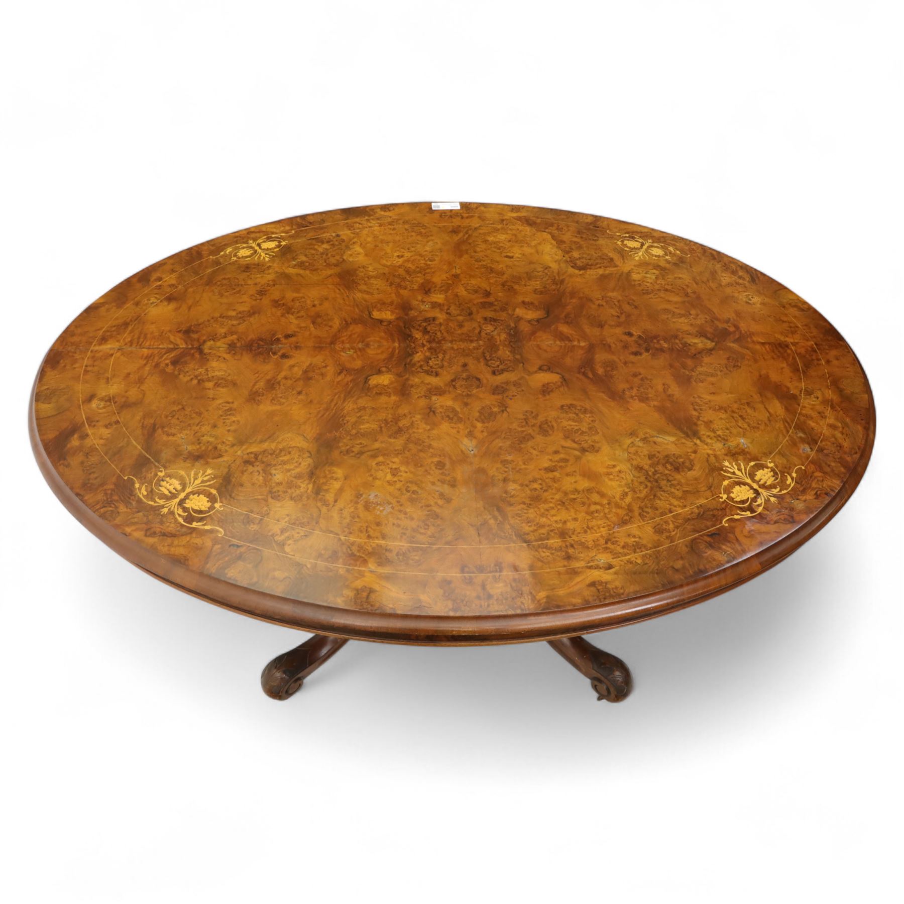 Victorian inlaid burr-walnut and marquetry oval centre table, quarter veneered tilt-top with scrolling foliate and floral marquetry reserves on a turned carved column with clustered supports raised on four out-swept scroll legs on ceramic castors  