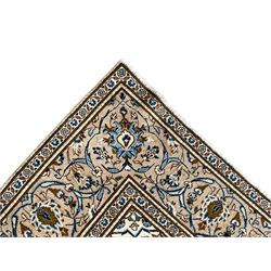 Persian Kashan ivory ground rug, the field decorated with interlacing branches and palmettes, central floral design pole medallion, the scrolling border decorated with stylised plant motifs, within repeating flower head guard stripes