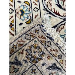 Persian Kashan ivory ground carpet, central pole medallion surrounded by swirling leafy branches and stylised plant motifs, scrolled foliate spandrels, the main border decorated with scrolling pattern and repeating palmettes, within floral patter guard stripes 