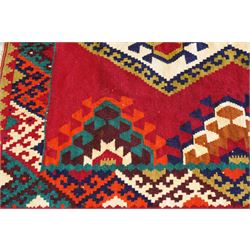 Persian Qashqai crimson ground rug, the central narrow ivory field decorated with repeating hooked geometric lozenges in multicolours, with a densely decorated guard band