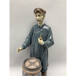 Lladro figure, 'Predicting the Future', modelled as a male donning hat with pipe standing above a barrel containing a dial with its lid removed, no. 5191, printed Daisa marks beneath, H29.5cm