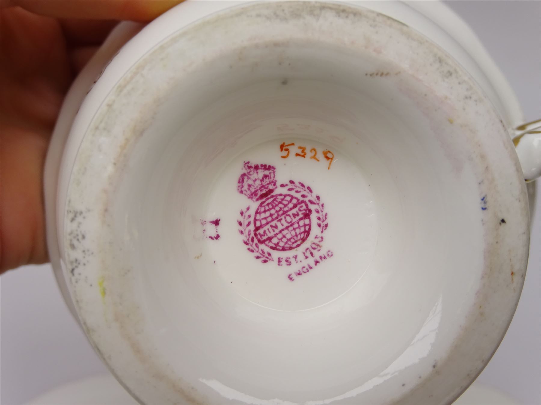 19th century Minton tea set, comprising twelve teacups, eleven saucers, fifteen side plates, cream jug, slop bowl, and two cake plates, decorated with panels of floral sprays, upon a green ground, heightened with gilt throughout, with printed puce mark beneath, and pattern number 5329
