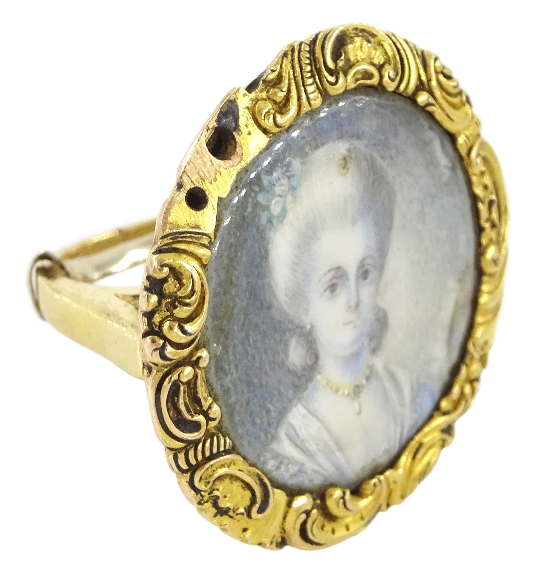 19th century gold portrait ring, set with a circular miniature of a young woman in 18th century dress on ivory, under a glazed panel, within a gold scroll frame and pierced gallery. This lot has been registered for sale under Section 10 of the APHA Ivory Act
