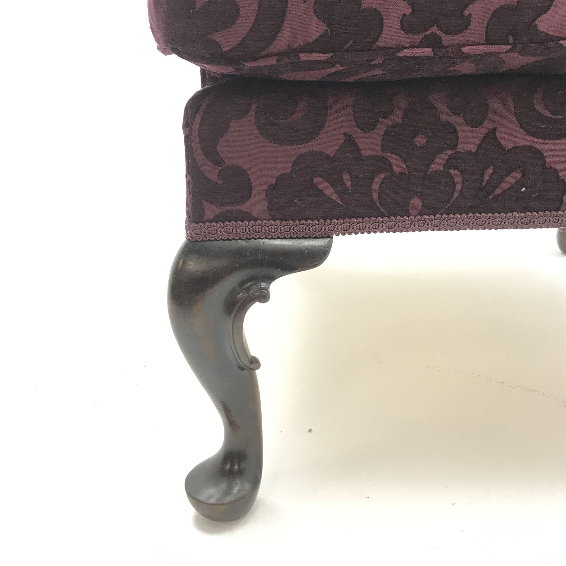 Traditional Queen Anne style high wingback armchair upholstered in purple fabric with raised scrolling pattern, on cabriole feet