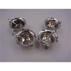 Set of four Edwardian silver open salts, of circular form, each with later personal engraving to scalloped rim and upon three pad feet, together with four matching silver salt spoons, hallmarked James Deakin & Sons, Sheffield 1909, in velvet and silk lined fitted case     