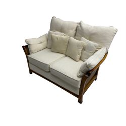 Pair mid-to late 20th century stained beech two seat sofas, upholstered in cream fabric