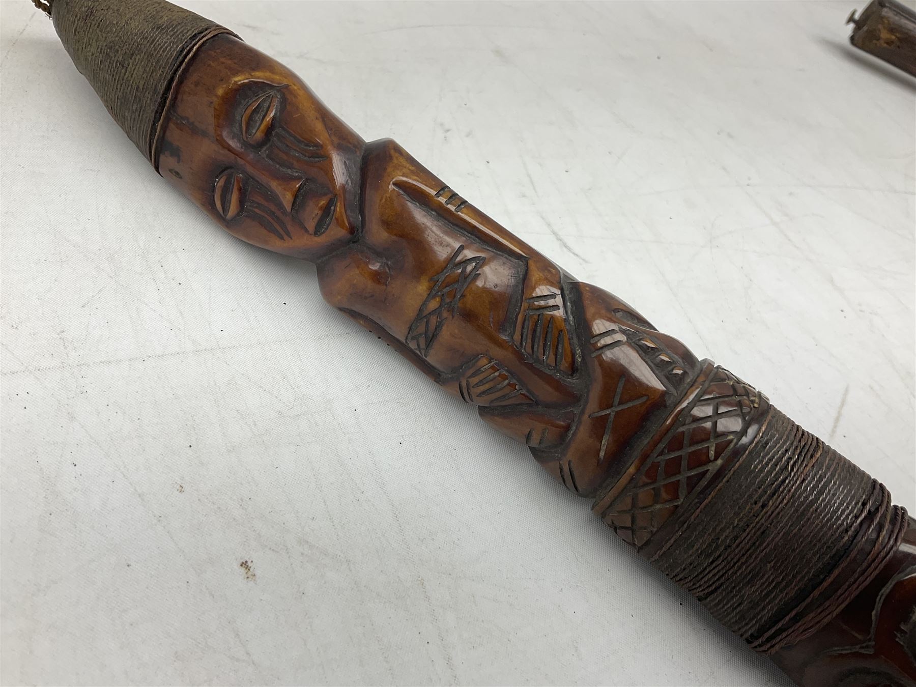 Tribal Art - an African axe, possibly Yoruba, the bone shaft carved as two cord bound stylised figures with iron fan-shaped blade, L35cm overall; and 19th century harpoon or spear head of square section with two long fixing arms on cut-down ash shaft L57cm (2)