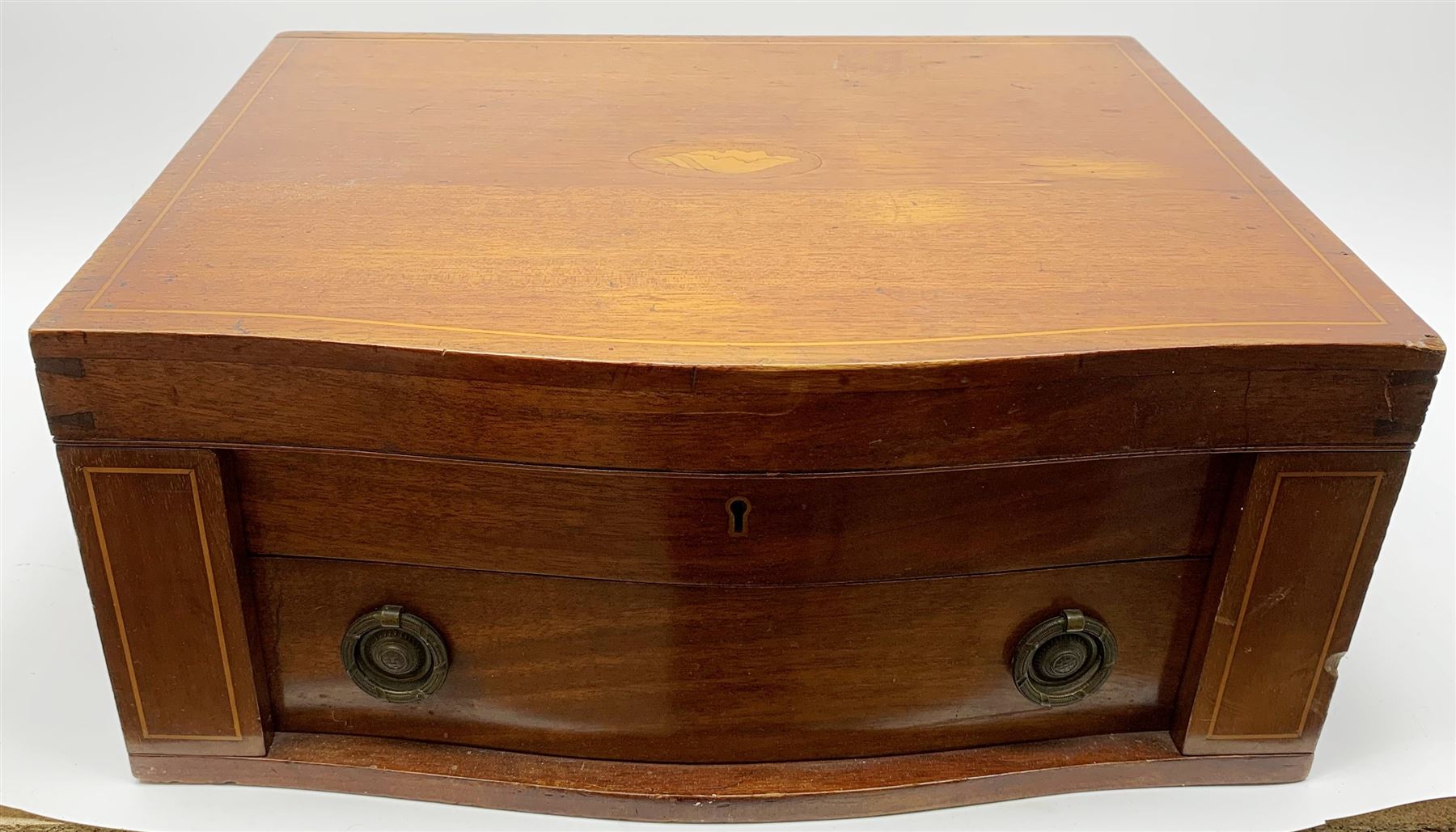 Late 19th/early 20th century composite canteen of silver flatware, contained within an early 20th century mahogany serpentine fronted case with twin drop carry handles, and hinged cover with boxwood stringing and central inlaid shell motif, above a single drawer with twin ring handles and Wellington style locking system, the cover and drawer opening to reveal plaque for Spink & Sons Ltd London, and fitted interior containing ivory handled knives, ivory handled carving set, and silver Hanoverian and Old English pattern cutlery, each with engraved monogram to terminal, hallmarked London, makers Spink & Son (John Marshall Spink), Goldsmiths & Silversmiths Co, and Chawner & Co (George William Adams), various dates ranging 1880-1923, gross weighable silver 92.59 ozt (2880 grams)