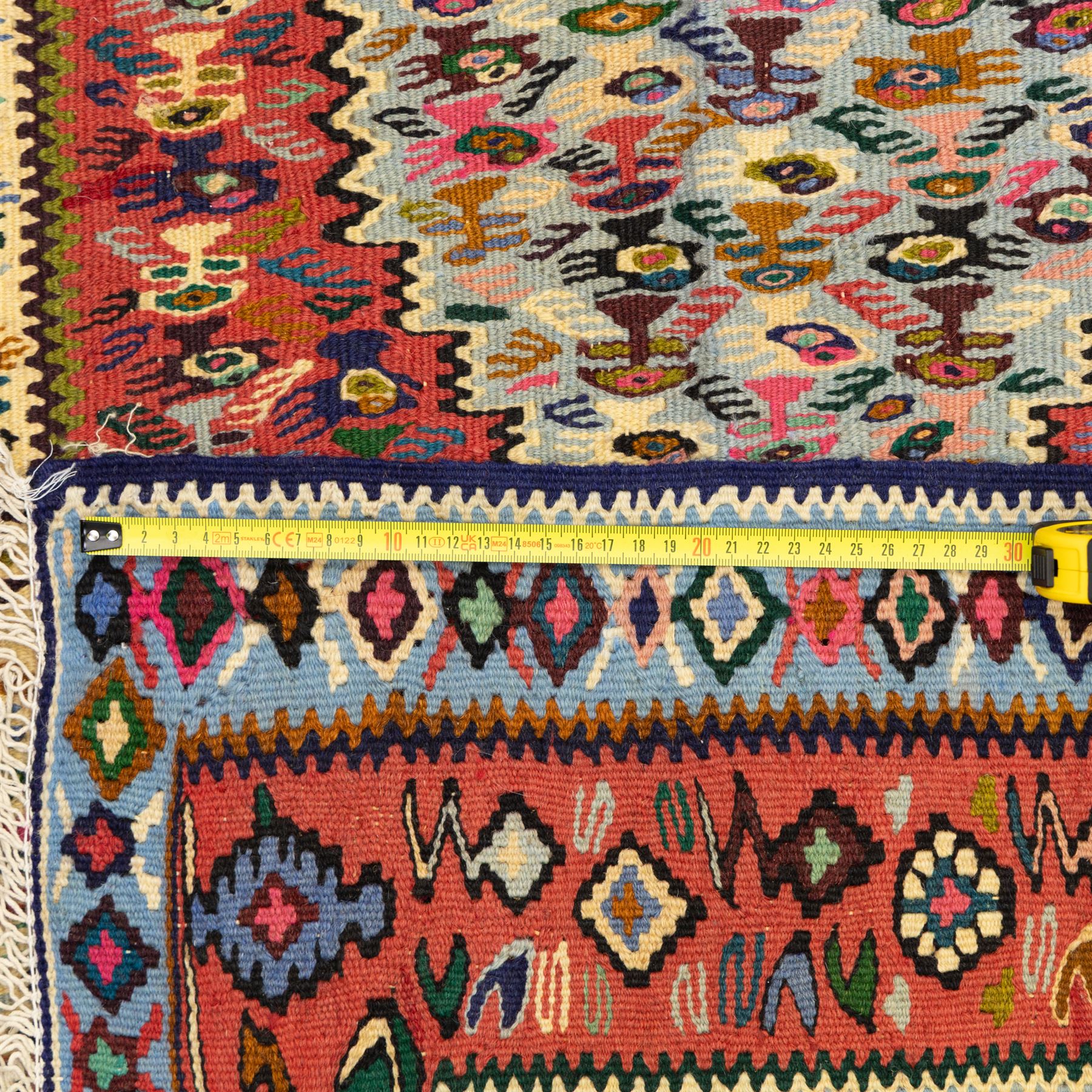 North West Persian Senneh kilim, finely woven wool with elongated central lozenge medallion on a densely patterned field of boteh motifs, in tones of red, ivory, indigo and ochre, framed by floral and diamond guard borders