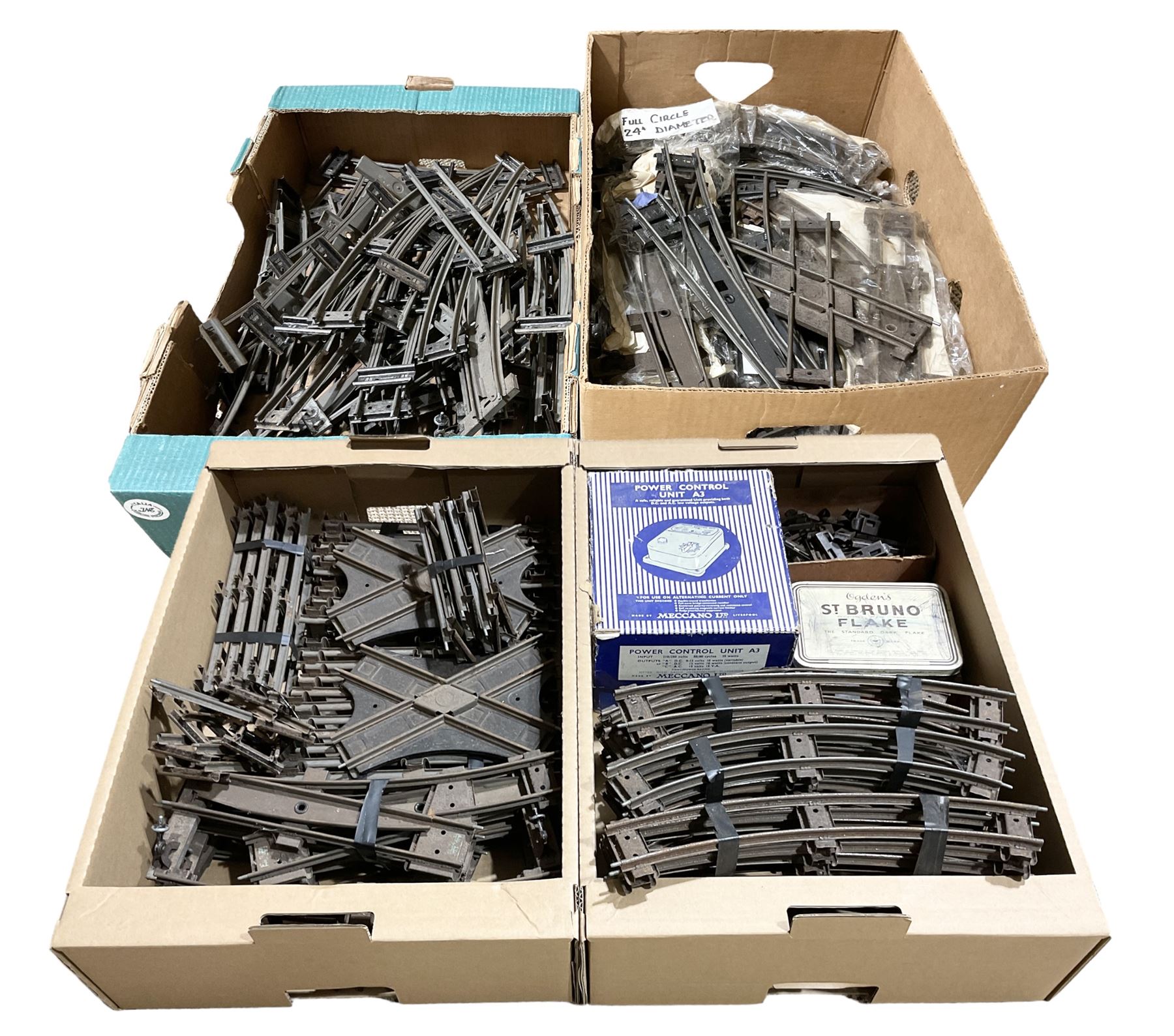 '0' gauge - large quantity of two-rail track with fixing clips including curves, straights, points, cross-overs etc; and boxed Meccano A3 Power Control Units; in four boxes