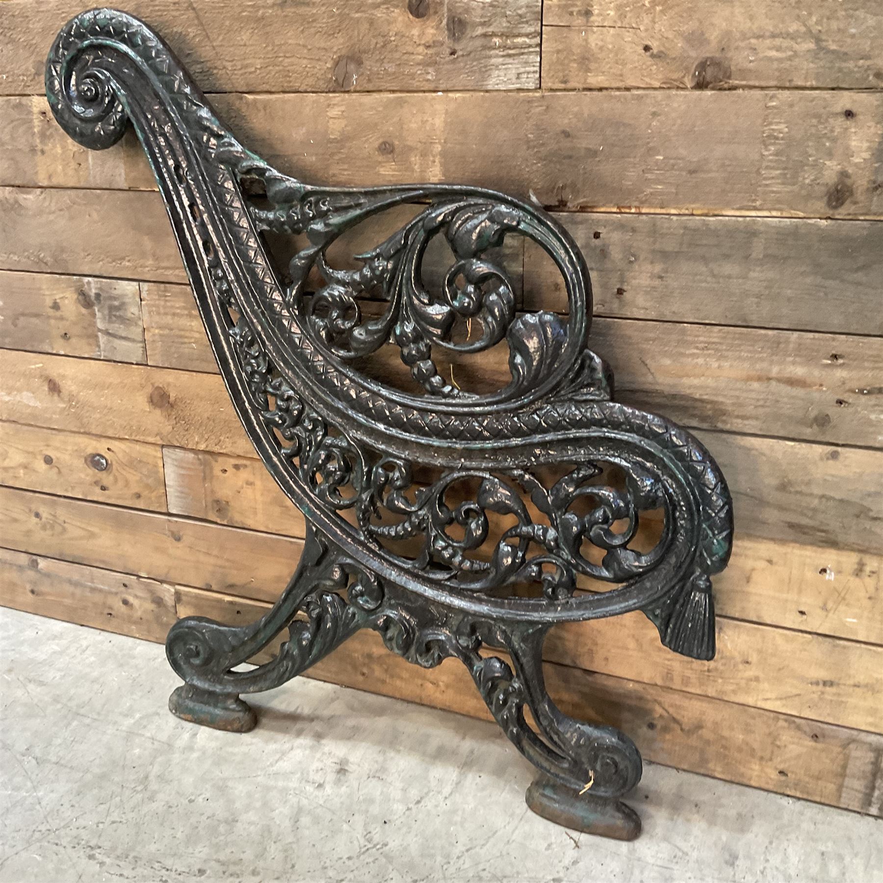 Early 20th century heavy cast iron three piece bench ends, decorated with scrolls and floral swags