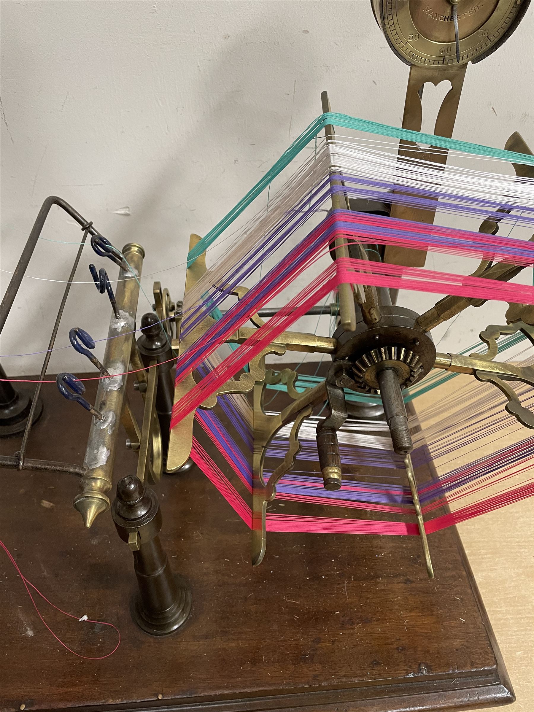 Victorian brass and cast metal wool winder by Goodbrand & Co, Manchester on a mahogany base, L70cm 