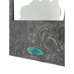 Art Nouveau period wall mirror, in repousse and hammer pewter frame decorated with herons in naturalistic landscape and set with oval mottled blue cabouchon  