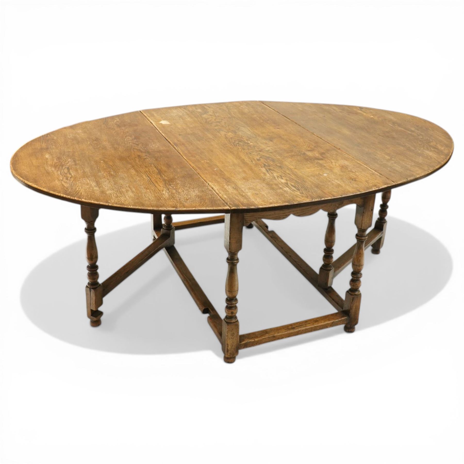 George III oak drop-leaf oval dining table with harlequin set of seven 18th century and later chairs including a comb-back Windsor, the table with turned gatelegs united by box stretcher, shaped apron extending to 212cm, the chairs of various forms, three Windsor carvers, a comb-back Windsor, plus a set of three Georgian mahogany dining chairs, pierced splat backs, with matching drop-in upholstered seats