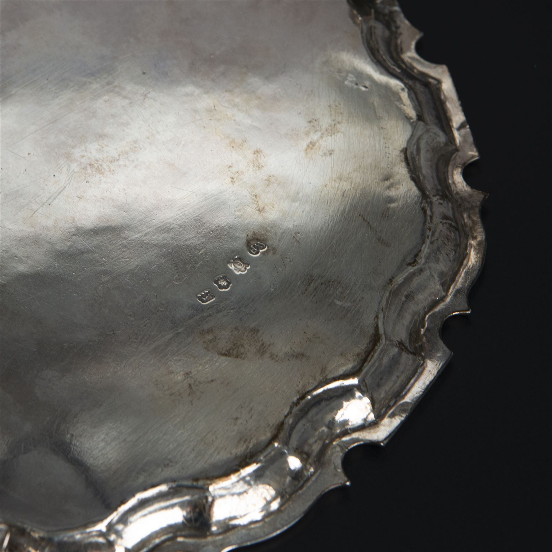 George II silver salver, of circular form with pie crust rim, with later floral and foliate decoration and presentation engraving to centre, upon three stepped feet, hallmarked William Peaston, London 1749, D30cm