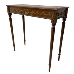 Early 20th century mahogany side table, inset amber leather surface, frieze decorated with applied gilt festoons and central wreath, on tapering fluted supports
