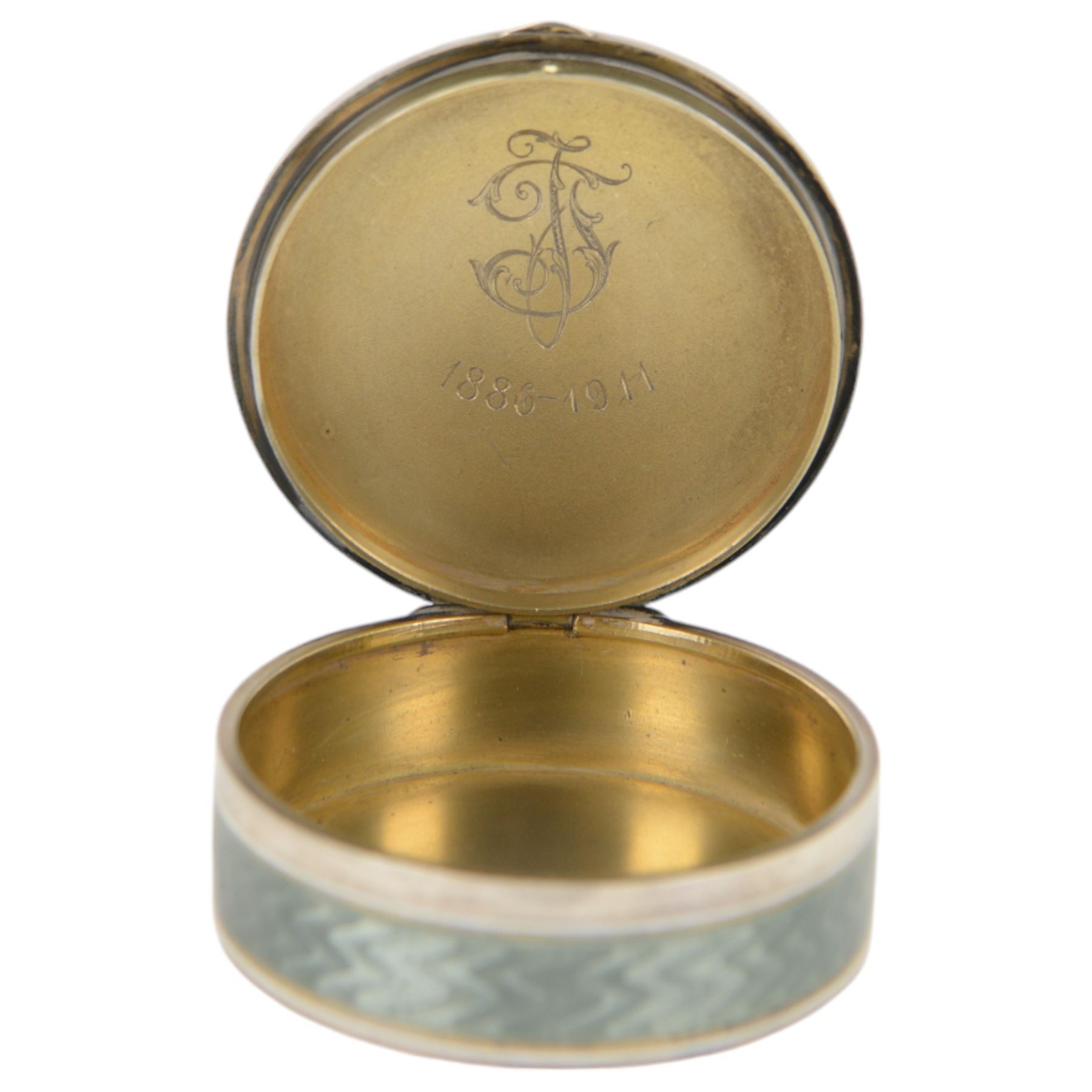 Early 20th century silver and guilloche enamel trinket box, of circular form, decorated throughout with pale green guilloche enamel and a floral wreath to the hinged cover, opening to reveal a gilt interior with personal engraving, import marks for Erich Kellerman, London 1909, D6cm