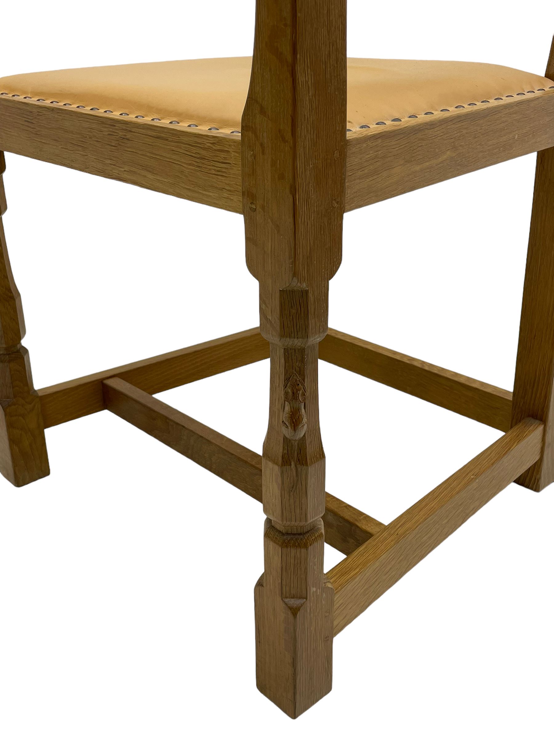 Mouseman - oak carver elbow chair, pierced and carved lattice back over leather upholstered seat with stud band, on octagonal supports united by plain stretchers, carved with mouse signature, by the workshop of Robert Thompson, Kilburn 