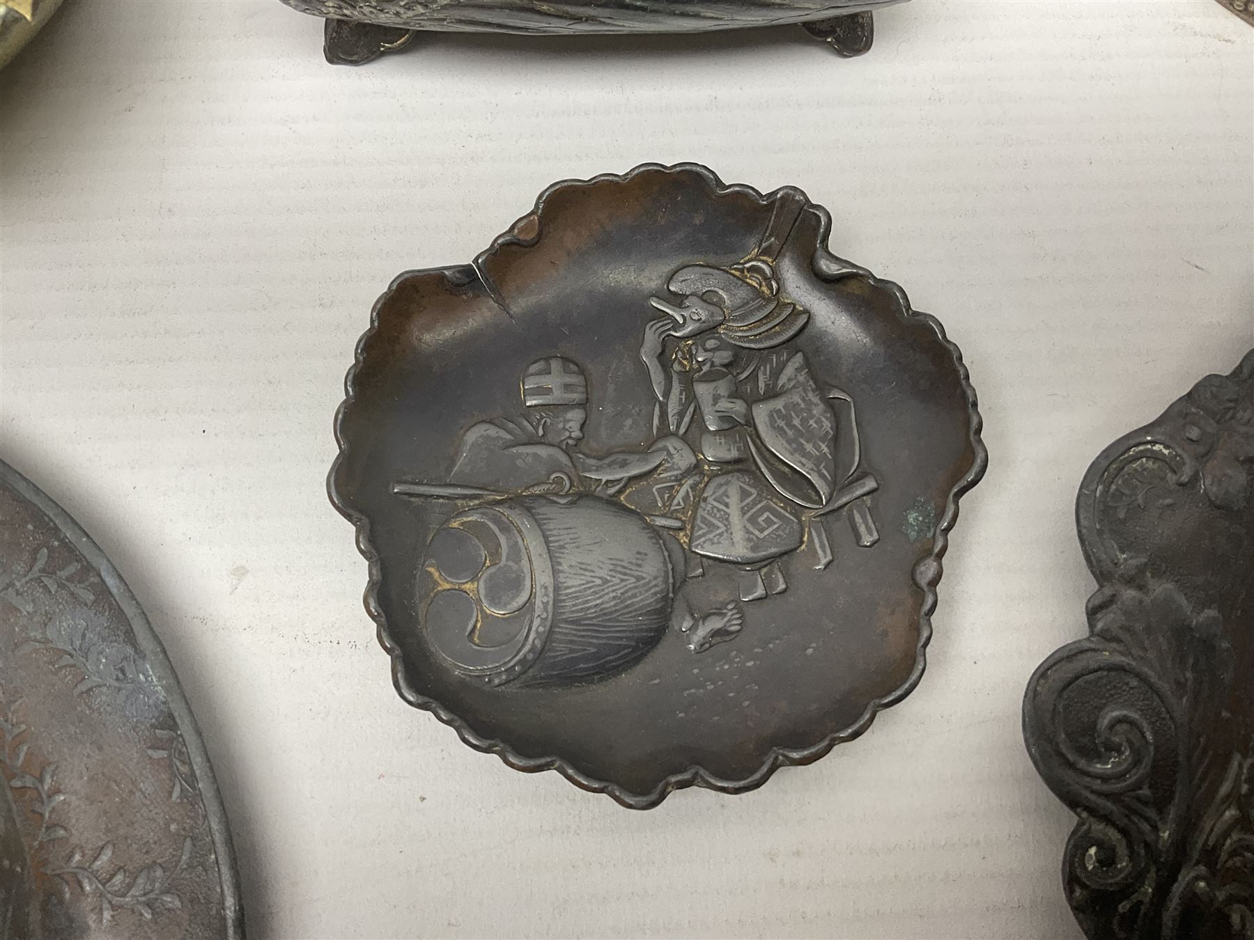 Brass sunfish ashtray, Chinese silver plated trinket box with mirror, bronzed matchbox cover and a collection of other Oriental bronzed embossed metal trays